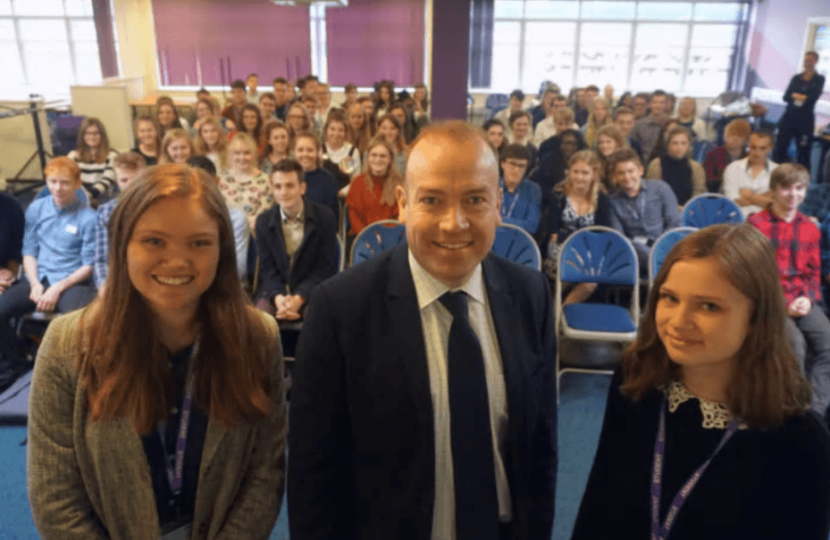 Pictured is Chris Heaton-Harris with Daisy Pierce and Poppy Martin, co-heads of the debating society.