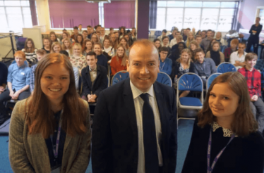 Pictured is Chris Heaton-Harris with Daisy Pierce and Poppy Martin, co-heads of the debating society.